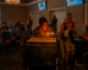 Woman blowing out candles on a birthday cake