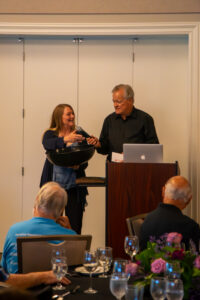 A woman and a man speaking from a podium