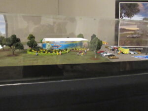 Building model with a salmon mural on the side, landscaping and figurines of visitors